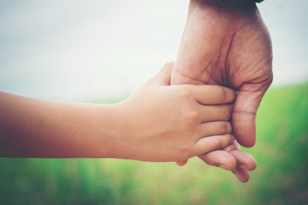 Close up of father holding his daughter hand, so sweet,family time.